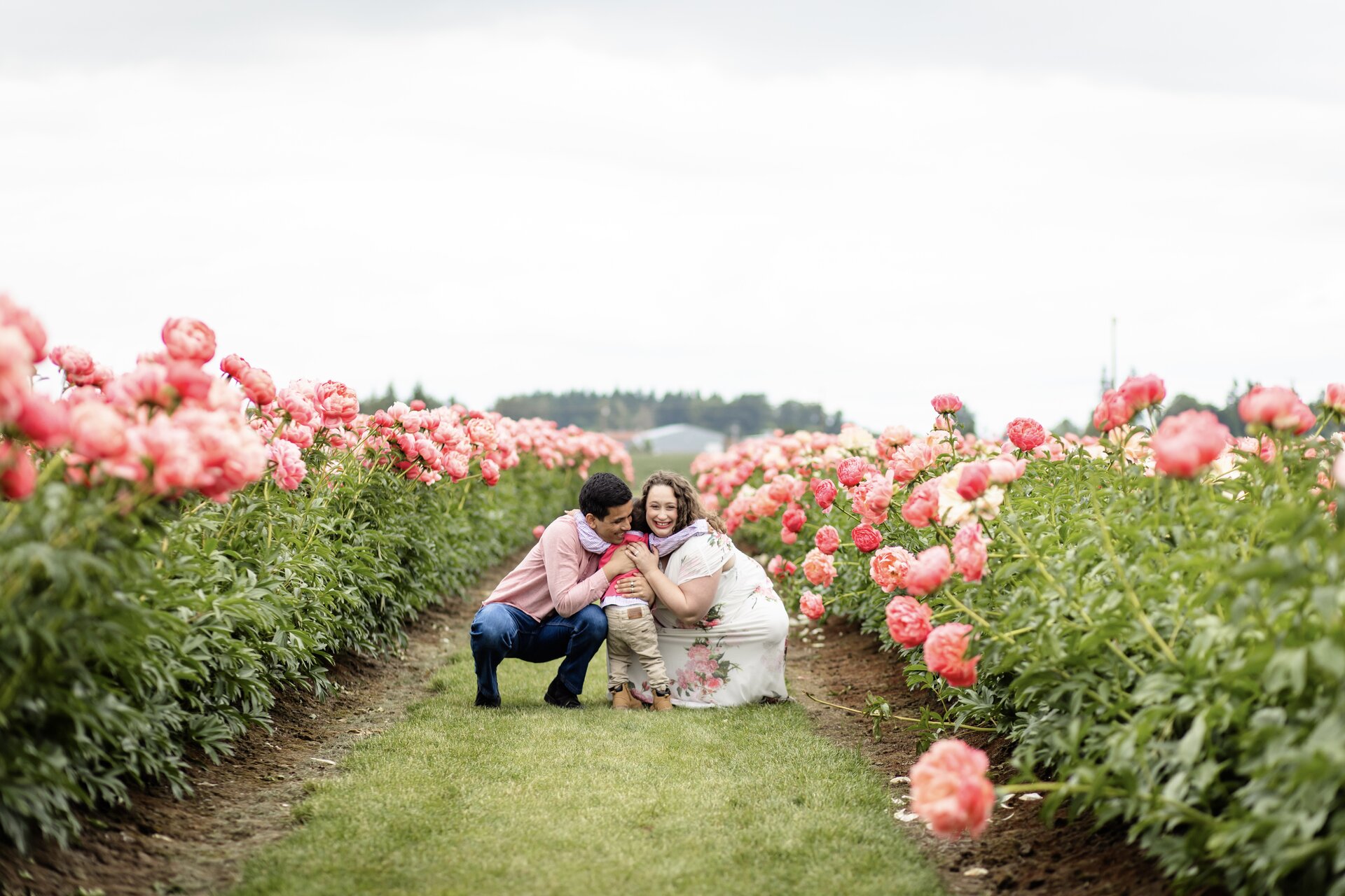 The Medina family hugging in a field of peonies