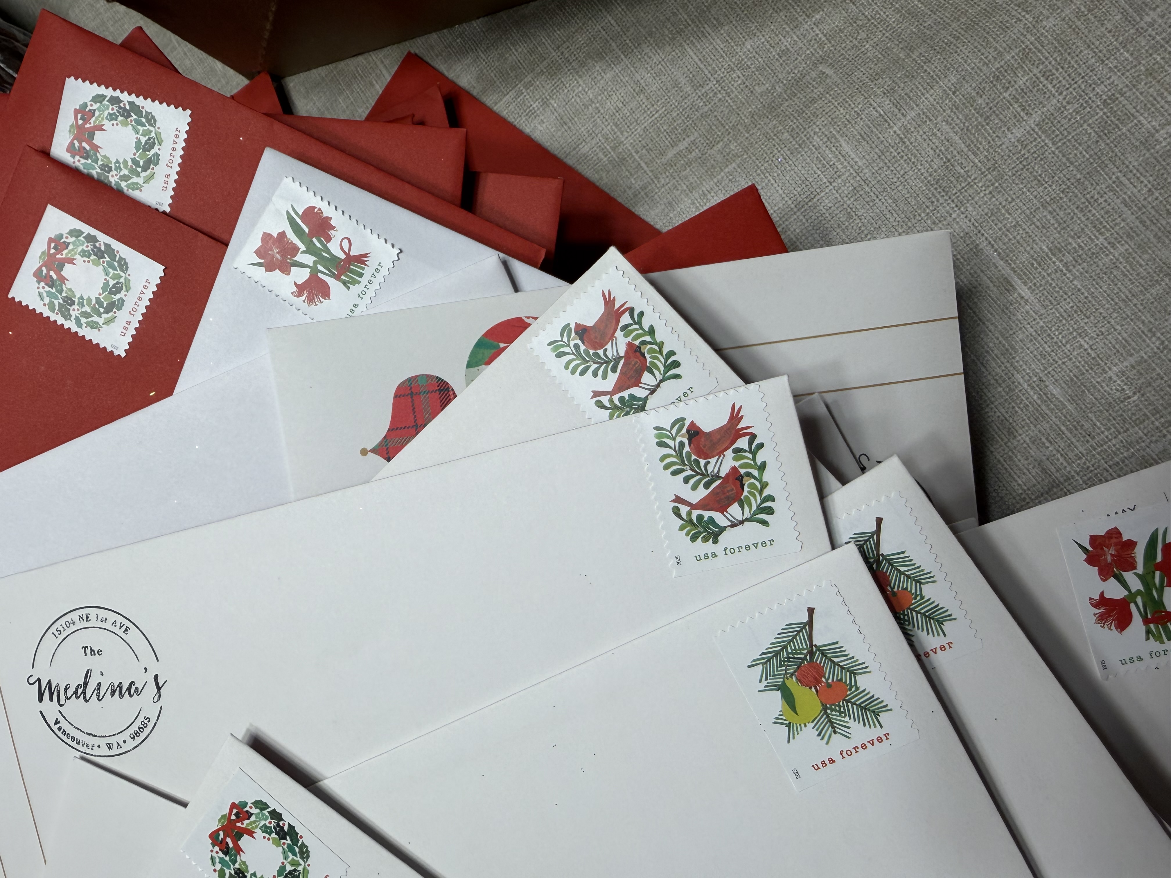 A stack of Christmas cards and envelopes on a table