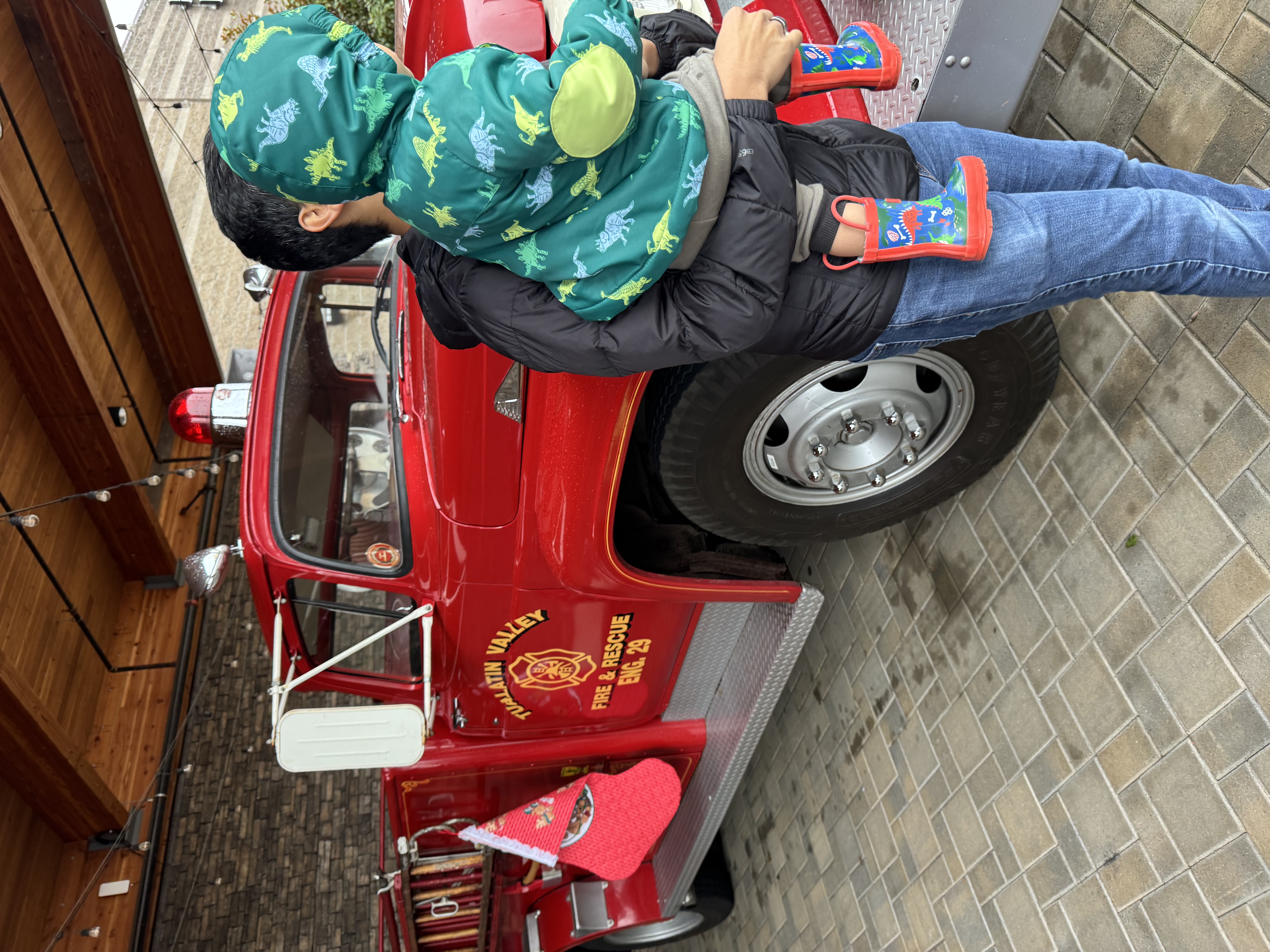 Toddler sitting on Santa's lap after arriving in a firetruck